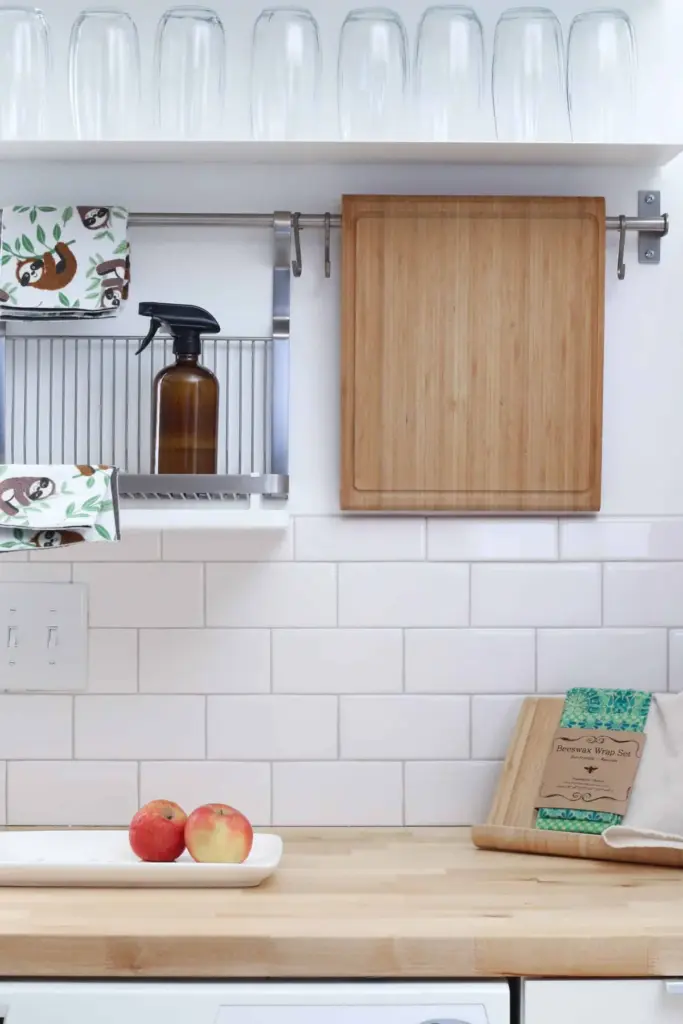 A clean kitchen counter with a spray bottle and a wooden chopping board
