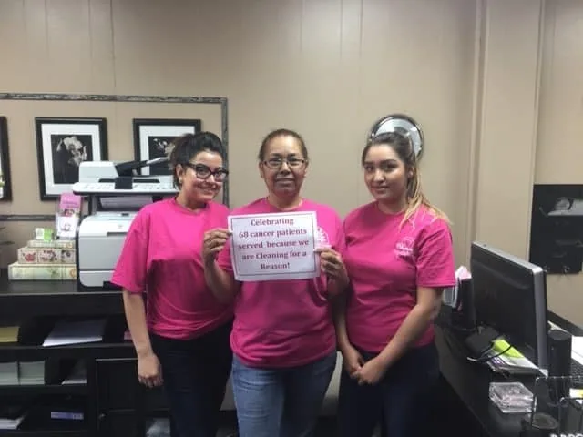 Three DomesticAide staff members in the Tulsa office holding a Cleaning for a Reason sign