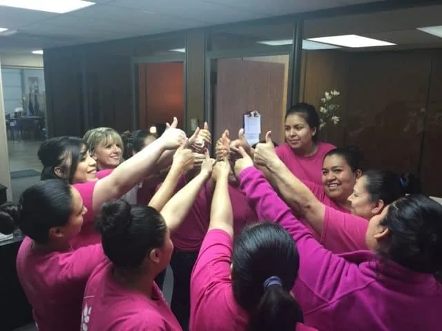 DomesticAide cleaners putting their hands together in a circle at the Tulsa office