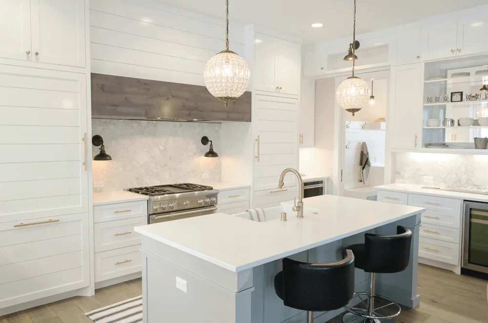 A clean white kitchen with a marble island, ready for a showing